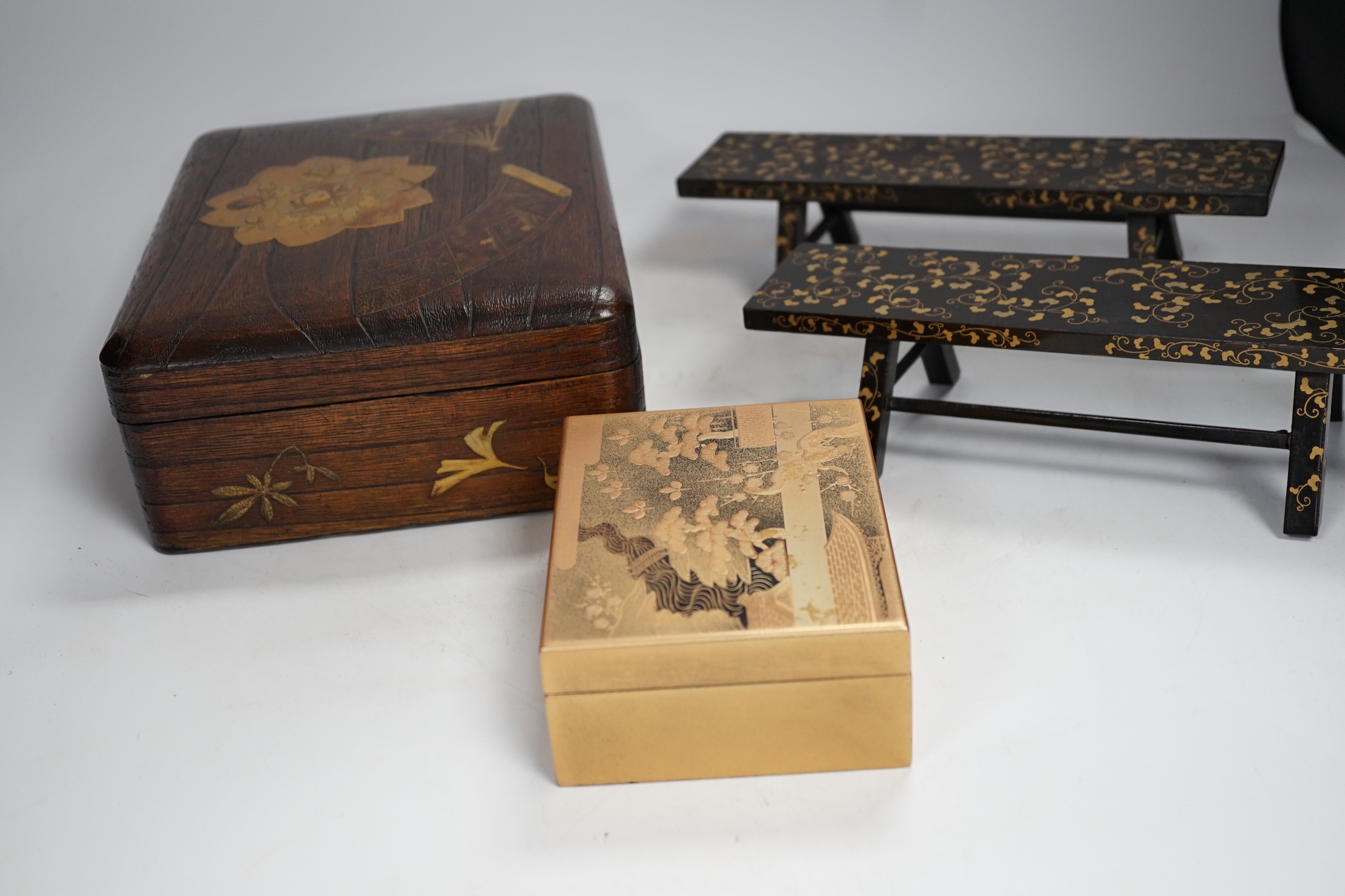 A group of Japanese lacquer wares, comprising pair of miniature benches and two boxes, Meiji period and later, largest 25cm wide